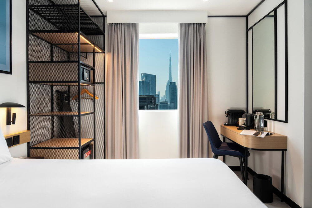 Guest room with a skyline window, a desk and a black metal wardrobe frame