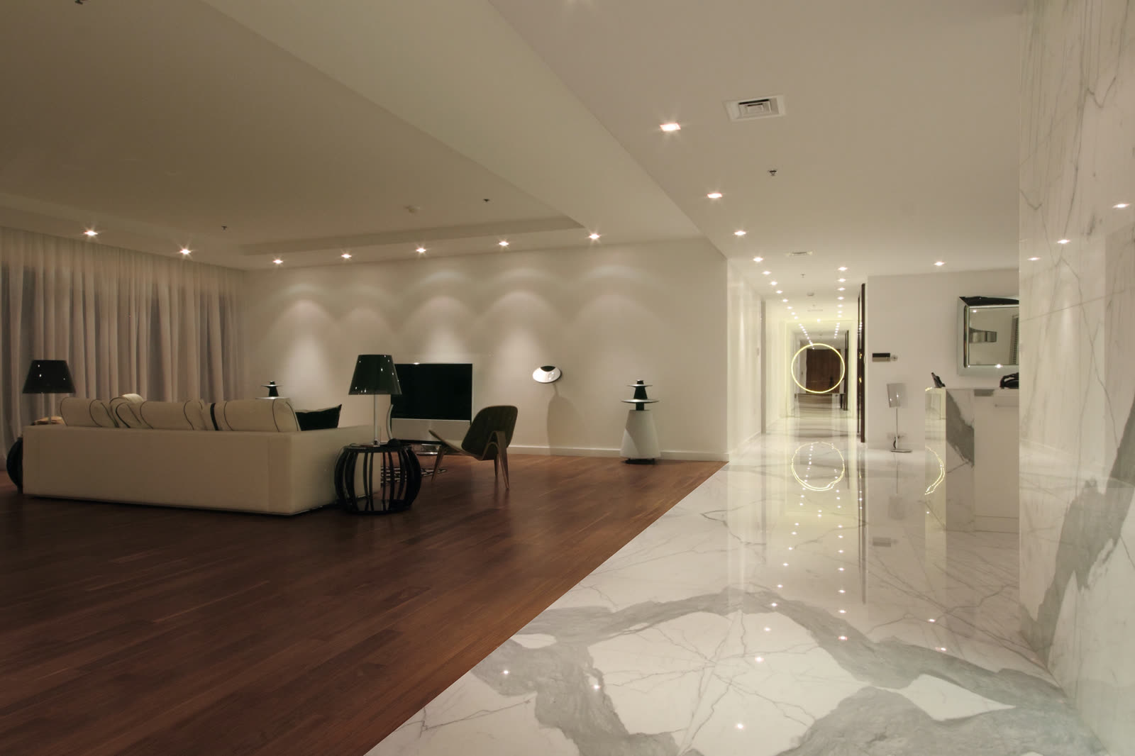 Penthouse lounge with a dark timber floor opening onto a marble gallery