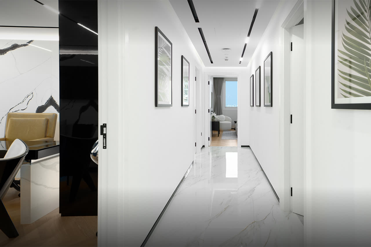 Marble-floored corridor with white walls and recessed lighting leading to a window